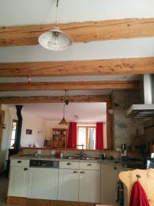 eine Küche mit Holzdecken, einem Waschbecken und einem Fenster in der Unterkunft Les Chanterelles Montmin in Plan Motmin