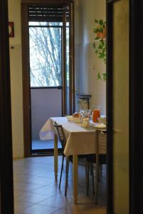 una sala da pranzo con tavolo, sedie e finestra di Salix Apartment a Padova