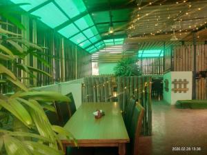 einen Tisch und Stühle in einem Zimmer mit Pflanzen in der Unterkunft Ocean Inn Hotels in Bangalore