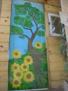 a mural of a tree with sunflowers on a wall at Casetta sull'Albero, Girasole in Castellammare del Golfo