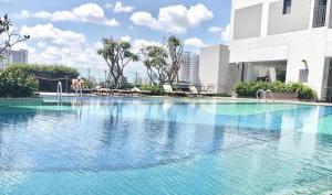 una gran piscina de agua azul frente a un edificio en SAIGON 9 - Rivergate Residence Infinity Pool, en Ho Chi Minh
