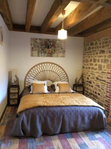 sypialnia z dużym łóżkiem i ceglaną ścianą w obiekcie Morvan Séjours w mieście Antully