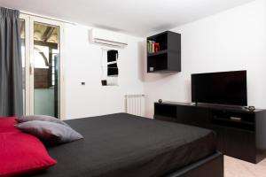 a bedroom with a bed and a flat screen tv at The Roof - Appartamento con terrazza al centro di Civitavecchia in Civitavecchia +4 photos