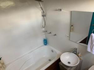 a bathroom with a white tub and a sink at El Bosque de Paipa in Paipa