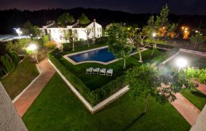 an aerial view of a house with a swimming pool at night at Apartamentos Golf Place in Borriol