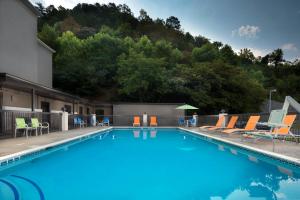 une piscine avec des chaises longues et une montagne dans l'établissement Holiday Inn Express Middlesboro, an IHG Hotel, à Middlesboro