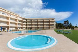 a resort with a swimming pool in front of a building at Front Beach Apartment - Quinta da Barracuda in Albufeira