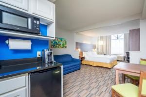 a hotel room with a king sized bed and a kitchen at Holiday Inn Express and Suites - Quakertown, an IHG Hotel in Quakertown