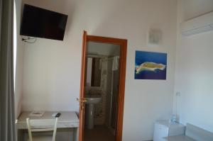 a bathroom with a television and a mirror at Il Veliero in Marzamemi
