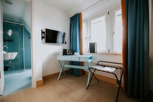 Habitación con escritorio, lavabo y ventana. en Palace St. George, en Mönchengladbach