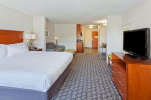 フェニックス・シティにあるHoliday Inn Express Phenix City-Fort Benning, an IHG Hotelのベッド1台、薄型テレビが備わるホテルルームです。