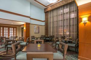 ein Restaurant mit Tischen und Stühlen und einem Fenster in der Unterkunft Staybridge Suites Wilmington - Brandywine Valley, an IHG Hotel in Glen Mills