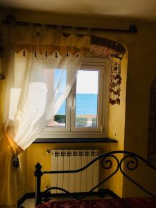 - une chambre avec un lit et une fenêtre donnant sur l'océan dans l'établissement Romantic Sea View Flat in Genova, à Gênes