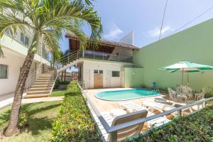 ein Haus mit einem Pool und einer Palme in der Unterkunft Pousada Mirante da Praia in São Miguel do Gostoso