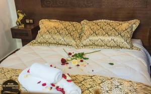 Una cama con dos toallas y flores. en Riad EL Manantial,Patrimonio del S XIX en Tetuán