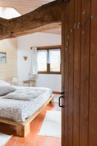 een slaapkamer met een bed en een houten deur bij L'instant jardin in Saint-Mars-de-Coutais