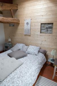 a bed in a room with a wooden wall at L'instant jardin in Saint-Mars-de-Coutais