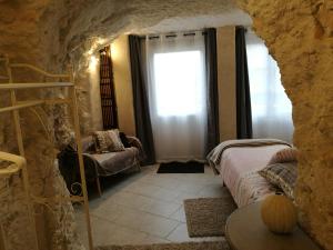 a bedroom with a bed and a window in a cave at Caves du Coteau 3 in Lunay