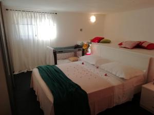 a bedroom with a bed and a window with red peppers on it at Apartments Berovic Kaprije in Kaprije