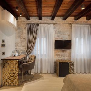 a bedroom with a bed and a desk and a television at Luxury Rooms MA de Dominis in Split
