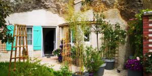 a garden entrance to a house with flowers and plants at Caves du Coteau 3 in Lunay