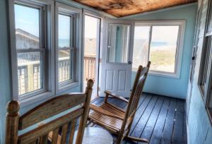 a wooden bench sitting in front of a window at Outer Banks Motel in Buxton