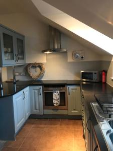 a kitchen with blue cabinets and a stove top oven at The Town House in Dornoch