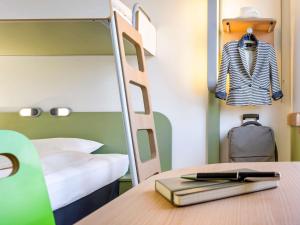 a bedroom with a bunk bed and a desk with a book at ibis budget Compiègne Centre-Ville in Compiègne
