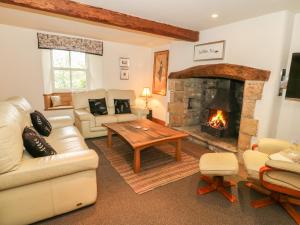 ein Wohnzimmer mit Couch und Kamin in der Unterkunft Bay Horse Cottage in Skipton
