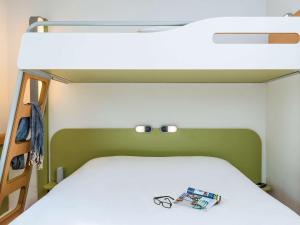 a bed in a room with a bunk bed at ibis budget Issy Les Moulineaux Paris Ouest in Issy-les-Moulineaux