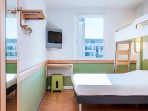 a hospital room with two beds and a tv at ibis budget Issy Les Moulineaux Paris Ouest in Issy-les-Moulineaux