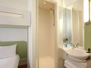 a bathroom with a sink and a shower and a toilet at ibis budget Tours Nord in Tours