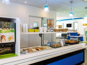 a bakery with a counter with bread and other food at ibis budget Paris Porte de Vincennes in Paris