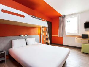 a bedroom with two bunk beds and an orange wall at ibis budget Paris Porte de Vincennes in Paris +35 photos