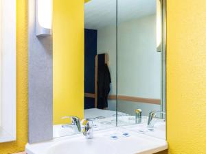 a bathroom with two sinks and a large mirror at ibis budget Paris Porte de Vincennes in Paris