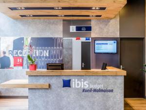 an ibis hotel lobby with a reception counter at ibis budget Rueil Malmaison in Rueil-Malmaison