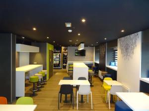 une salle à manger avec des tables et des chaises dans un restaurant dans l'établissement ibis Budget Caen Centre Gare, à Caen