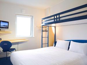 a bedroom with a bunk bed and a desk at ibis budget Marne la Vallée Val d'Europe in Montévrain