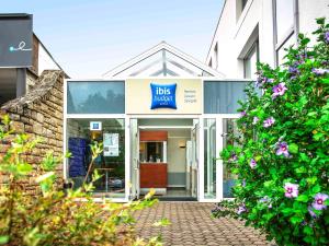 a building with a ups label sign on the front of it at Hotel Ibis Budget Rennes Cesson in Cesson-Sévigné