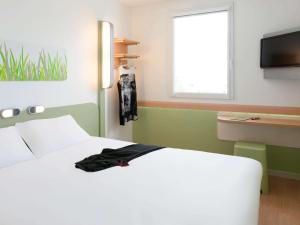 A bed or beds in a room at Hotel Ibis Budget Lyon Eurexpo -