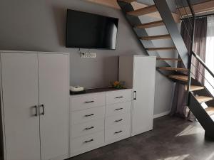 a white cabinet with a television on top of it at Apartament Fala in Mechelinki