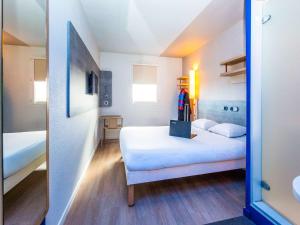 a bedroom with a bed and a desk at ibis budget Marmande in Marmande
