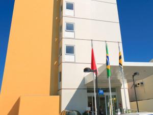 um edifício com três bandeiras à sua frente em ibis budget Belem em Belém