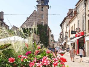 una calle con flores y un edificio con una torre de reloj en ibis budget Nuits Saint Georges, en Nuits-Saint-Georges