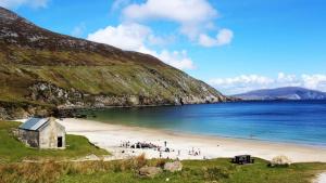 a group of people on a beach near the water at Ocean View one bedroom cozy apartment in Achill