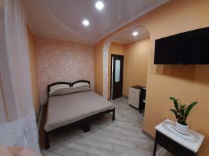 a bedroom with a bed and a flat screen tv at Mini-hotel in Umanʼ