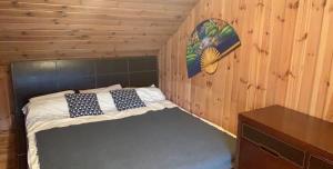 una piccola camera da letto con un letto in una camera in legno di Dom Pod Sosnami a Rzewnie