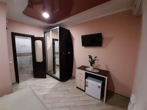 um quarto com um toucador, um espelho e uma televisão em Mini-hotel em Umanʼ