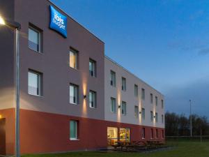 a building with a blue sign on the side of it at ibis budget Romorantin in Romorantin