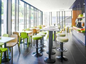 een restaurant met tafels, stoelen en ramen bij ibis budget Gare de Poitiers in Poitiers